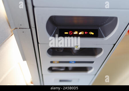 Fasten seat belt and no smoking sign in aircraft. Airplane cabin interior. Shallow DOF Stock Photo
