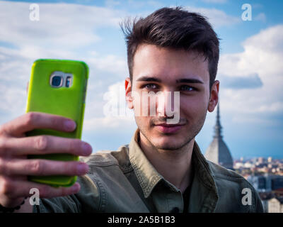 Young attractive man taking selfie photo outdoor in city Stock Photo