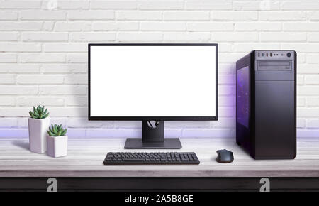 Gaming PC on white desk. Isolated screen for mockup. Brick wall in background. Stock Photo