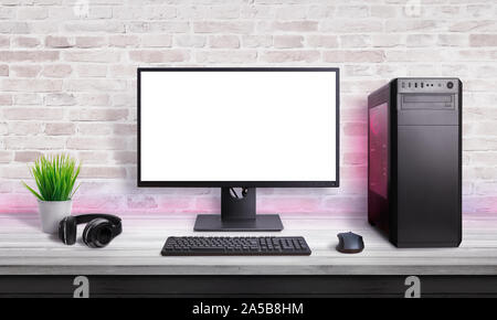 Desk with gaming setup. Display with isolated screen for mockup. Gaming PC,  headset, keyboard, mouse and joypad on desk. Purple led light on wall Stock  Photo