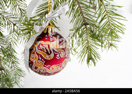 Christmas ball hanging on snowy fir tree Stock Photo