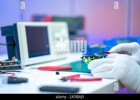 Development of electronic devices in the modern electronics laboratory, on a table, microprocessor oscilloscope and multimeter Stock Photo