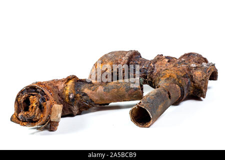 Fragments of old cast-iron water pipes on white background. After many years of operation corroded metal pipe was destroyed. Rusty steel tube with Stock Photo