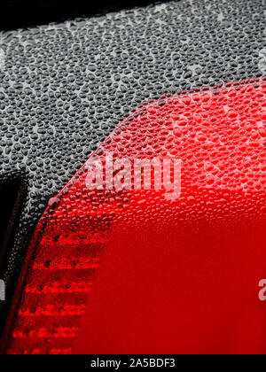 Wet beautiful car Headlamp, black car with water drop. Close up Side view shot from side of vehicle. Detailing concept. Stock Photo