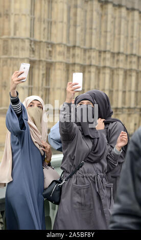 Muslim women wearing face veils or niqab take selfies at Westminster, London, UK Stock Photo