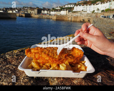 Fish and Chips, traditional English fish and chips, close up of portion of fish and chips at Porthleven harbour, Cornwall, UK Stock Photo