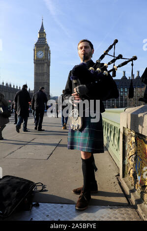 Man plays bagpipes by Big Ben, London, UK Stock Photo