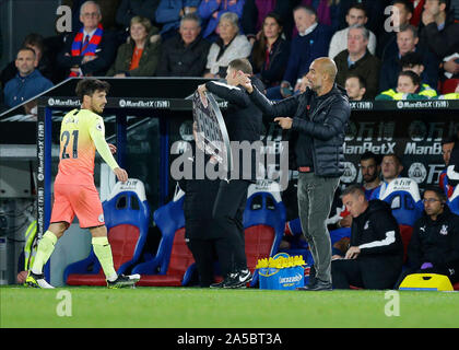 19th October 2019; Selhurst Park, London, England; English Premier League Football, Crystal Palace versus Manchester City; Manchester City manager Pep Guardiola gives instructions from the touchline during the 2nd half with David Silva of Manchester City looking at Manchester City manager Pep Guardiola while being subbed off - Strictly Editorial Use Only. No use with unauthorized audio, video, data, fixture lists, club/league logos or 'live' services. Online in-match use limited to 120 images, no video emulation. No use in betting, games or single club/league/player publications Stock Photo