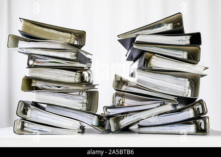 stacks of many ring binder with files, folders and documents on an office desk, concept for too much work and burn out in the business, selected focus Stock Photo