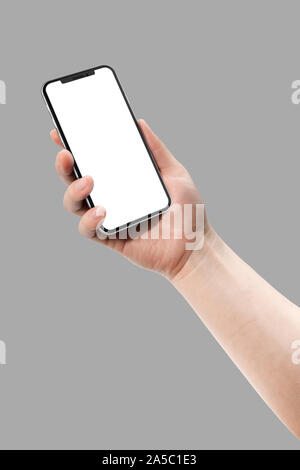 Woman hand holding smart phone with blank screen isolated on gray. Template, mockup, model, modern, design. Stock Photo