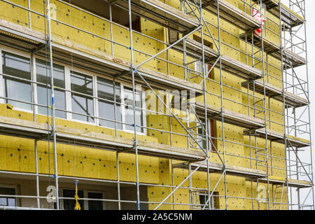 scaffolding arround the house to install thermal insulation of the apartment building facade Stock Photo