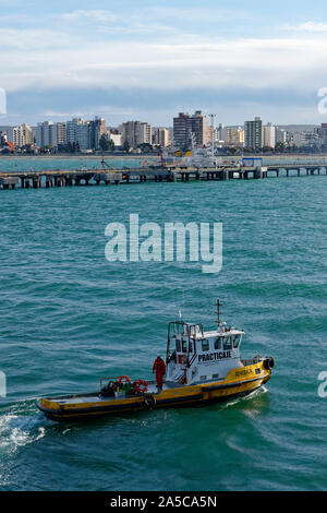 View of Puerto Madryn from the bay with a pilot boat in front, Chubut, Patagona, Argentina Stock Photo