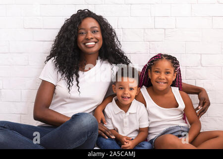 Young african mother with her children sitting together on floor Stock Photo