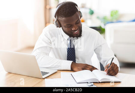 Creative businessman listening to music at workplace, planning future Stock Photo