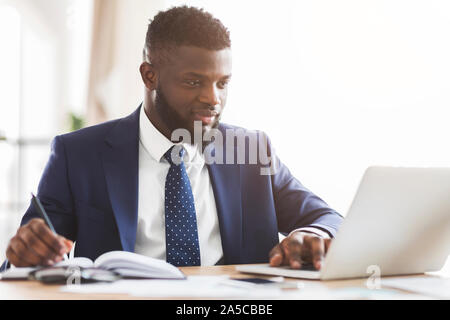 Young handsome manager making market research online Stock Photo