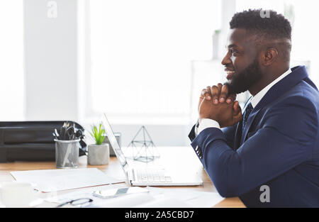 Cheerful black manager planning future at office Stock Photo