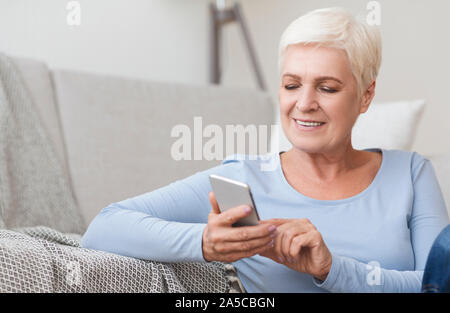 Image of modern senior woman using phone Stock Photo