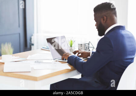 Back view of young businessman working with laptop in office Stock Photo