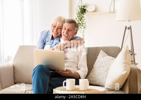 Happy senior couple having video call on laptop Stock Photo