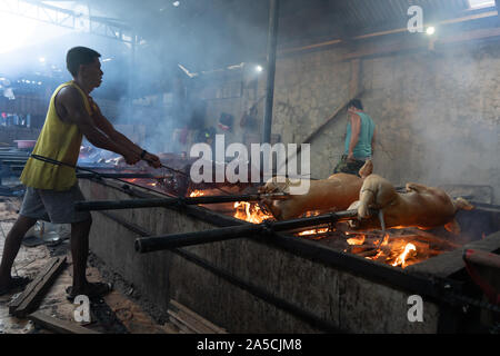 Spit Roasted pigs being cooked slowly over wooden embers in talisay City,Cebu. Known as ‘Lechon Baboy’ in the Philippines, was once acclaimed as ‘The best pig ever’ by celebrity chef,sadly now deceased,Anthony Bourdain. As the National dish of the Philippines ‘Lechon baboy’ is a firm favourite with Filipinos throughout the year but particularly during special events such as birthdays,Fiestas and Christmas time where literally hundreds of thousands of pigs will be roasted. The Province of Cebu is regarded as having the best Lechon in the Philippines. Purveyors of Lechon have their own closely g Stock Photo