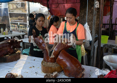 Spit roasted pig being chpped into retail size portions by a vendor at Talisay City,Cebu.Known as ‘Lechon Baboy’ in the Philippines, was once acclaimed as ‘The best pig ever’ by celebrity chef,sadly now deceased,Anthony Bourdain. As the National dish of the Philippines ‘Lechon baboy’ is a firm favourite with Filipinos throughout the year but particularly during special events such as birthdays,Fiestas and Christmas time where literally hundreds of thousands of pigs will be roasted. The Province of Cebu is regarded as having the best Lechon in the Philippines. Purveyors of Lechon have their own Stock Photo