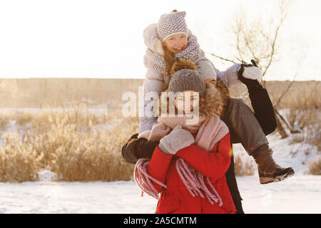 Happy friends cuddling and posing in winter holiday in a snowy sunny day. Having fun playing in snow outdoors. Winter best time for cheery Stock Photo