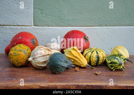 Closeup of colorful pumpkins on the wooden table outside the house Stock Photo