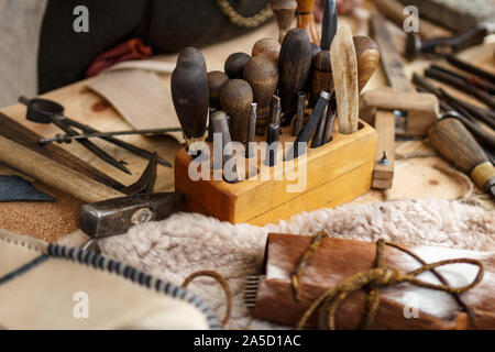 Set of leather working tools on working desk Stock Photo