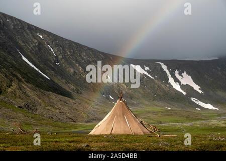 A rainbow surrounds a chum on the tundra in Siberia, Russia Stock Photo
