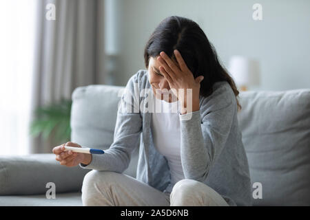 Stressed biracial young girl worrying about unwished pregnancy. Stock Photo