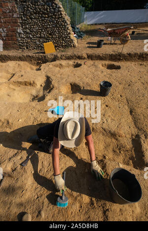 Archaeologist  excavating artifacts at an archaeological dig site Stock Photo