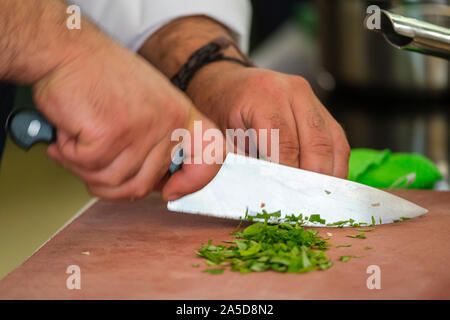 Person chopping herbs with a chef knife Stock Photo