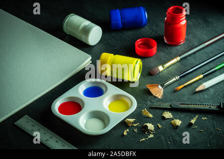Art materials and poster color bottle on black cement floor. Concept of art education. Stock Photo