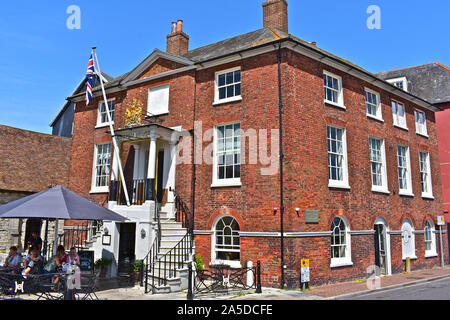 The Custom House Café on the quayside in Old Poole, with views across the harbour. People enjoying the summer sun sitting outside this historic house. Stock Photo