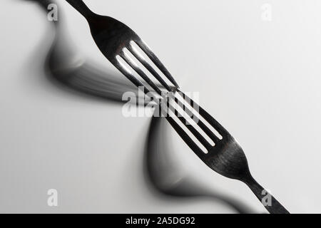 the drawing of the shadows of the forks on a white surface Stock Photo