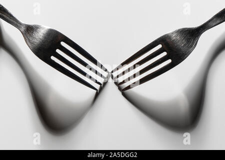 the drawing of the shadows of the forks on a white surface Stock Photo