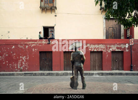 Street scene with the monument of Jorge Negrete (famous Mexican Singer) watching a couple talking outside. Guanajuato, Mexico, Jun 2019 Stock Photo