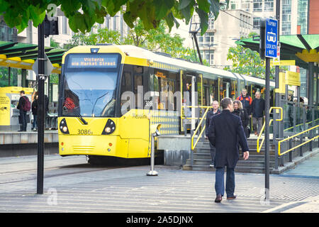 2 November 2018: Manchester, UK - Metrolink tram at tram stop in St Peter's Square in the CBD, people getting on and off. Stock Photo