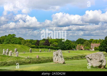 8 June 2019: Avebury, Wiltshire, UK - Tourists strolling around the Avebury Stone Circle, the largest henge in the nworld, on a bright summer day. Stock Photo