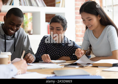Indian, african, asian classmates do school assignment together indoors Stock Photo