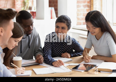 Focused multi national students sitting at desk studying together Stock Photo