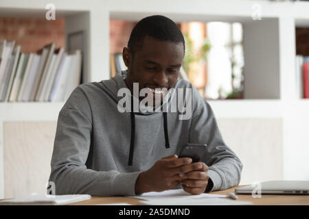 African man holds smartphone looks at screen read media news Stock Photo