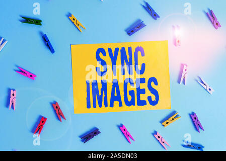 Handwriting text Sync Images. Conceptual photo Making photos identical in all devices Accessible anywhere Colored clothespin rectangle shaped reminder Stock Photo