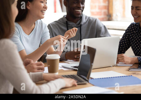 Multinational group of students take break chatting laughing in classroom Stock Photo