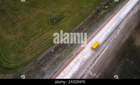 yellow bus rides on the road top view Stock Photo