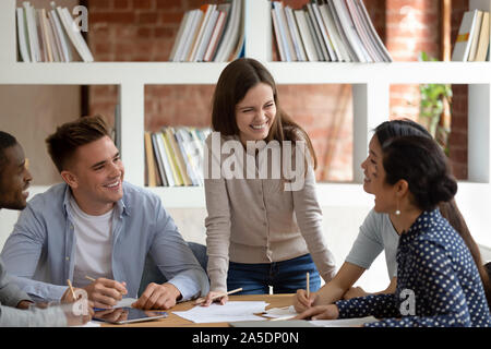 Multiracial students listen caucasian girl team leader do common task Stock Photo