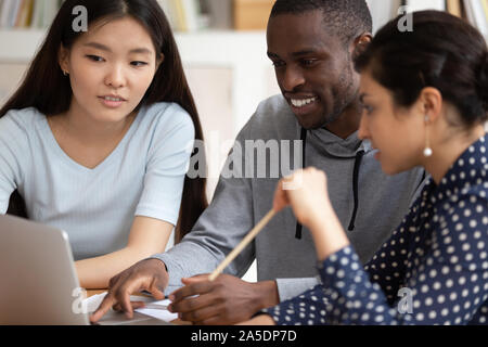 Multi-ethnic students sitting in classroom using computer educational apps Stock Photo