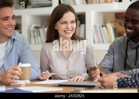 Multi-ethnic students distracted from learning process telling jokes laughing Stock Photo