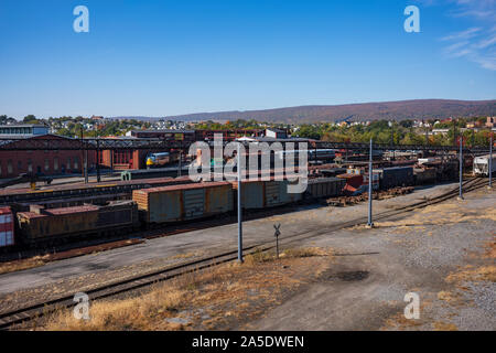 Vintage train cars and locomotives, covered in rust and are in disrepair, rest on tracks in Scranton, PA, USA. Stock Photo