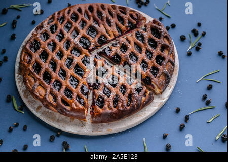 Close-up homemade open cake with black currant on a dark blue background. Stock Photo